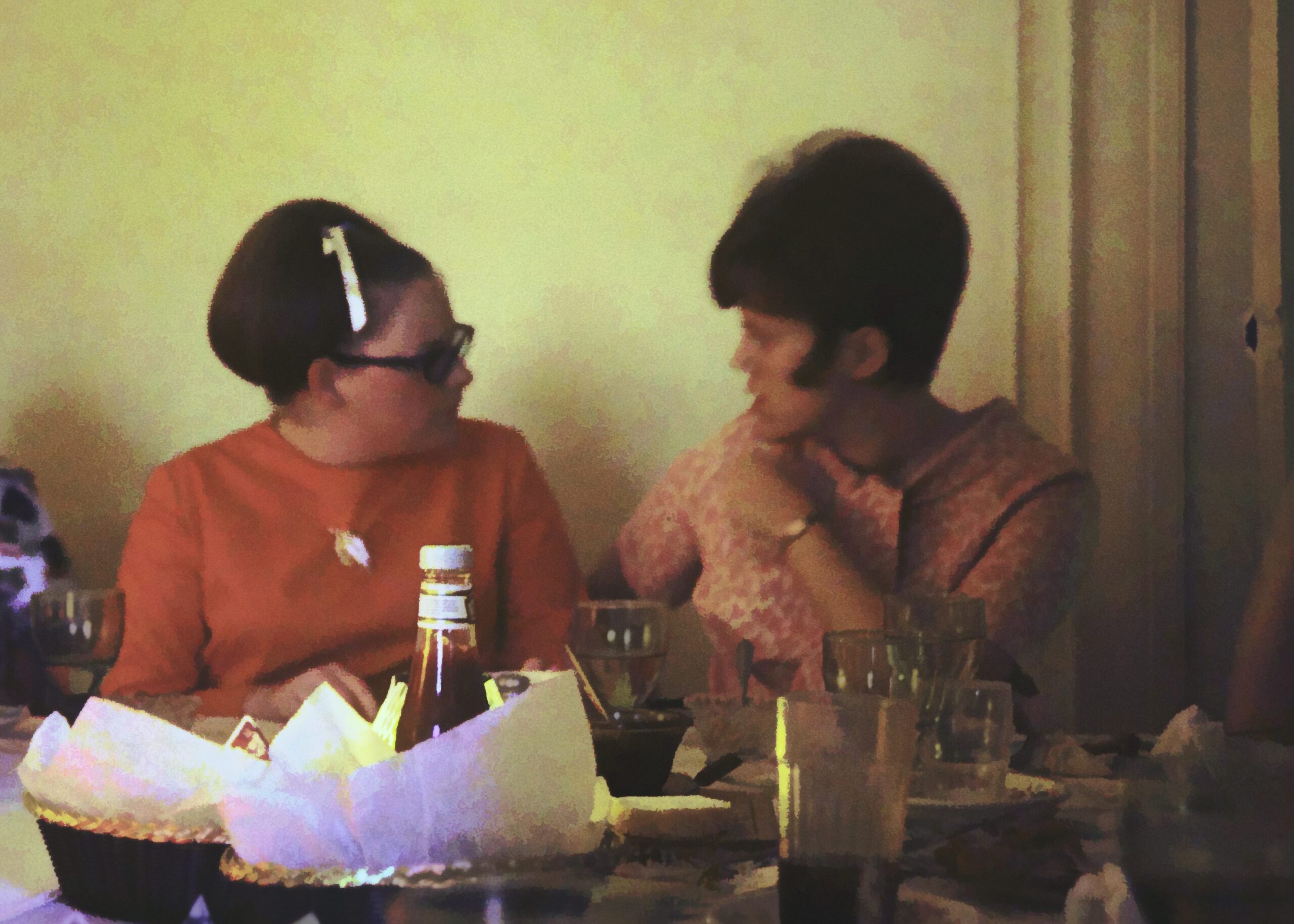 Two young women from 1971 conversing over dinner