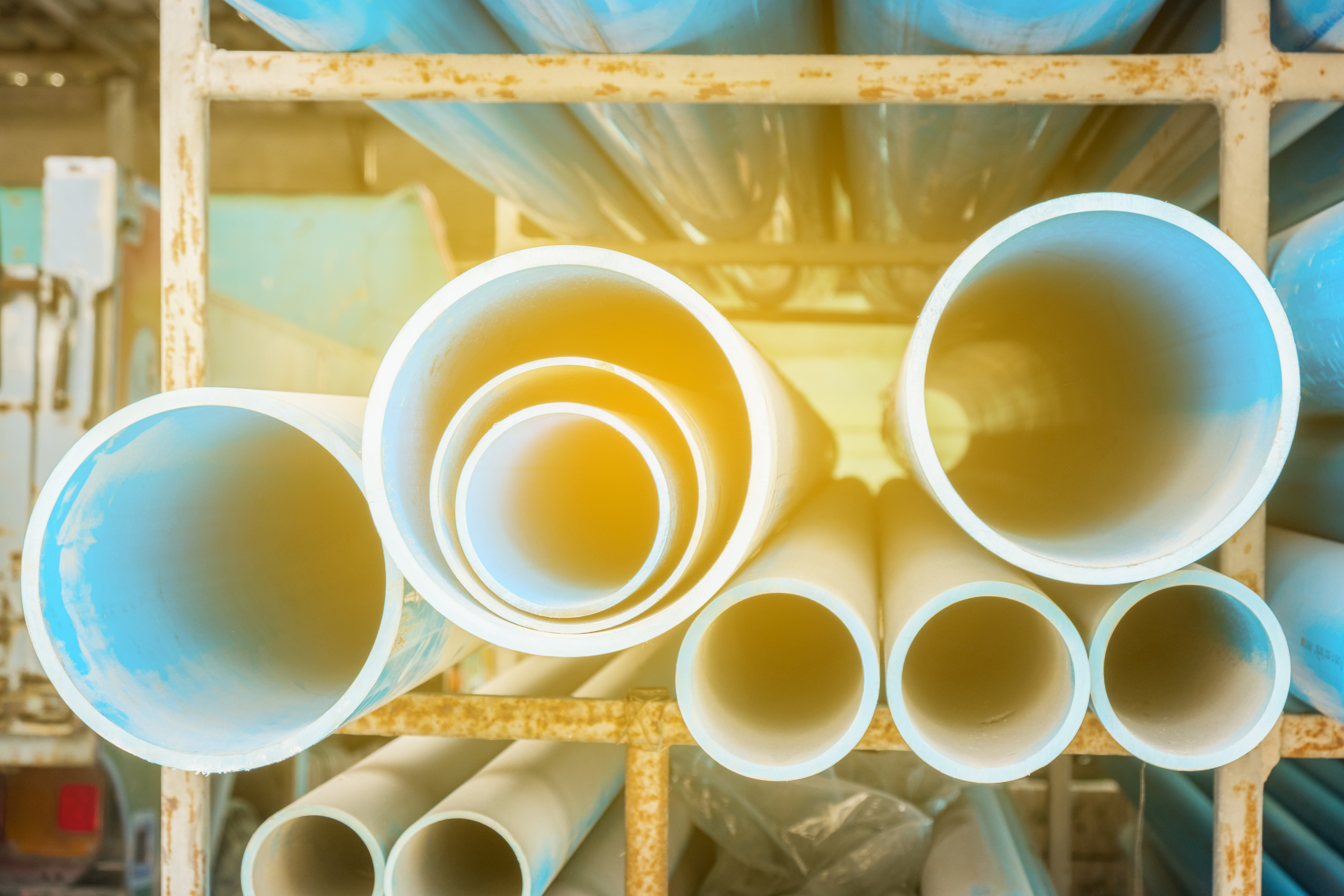 Stacks of PVC water pipes in warehouse, Selective focus BCS Management