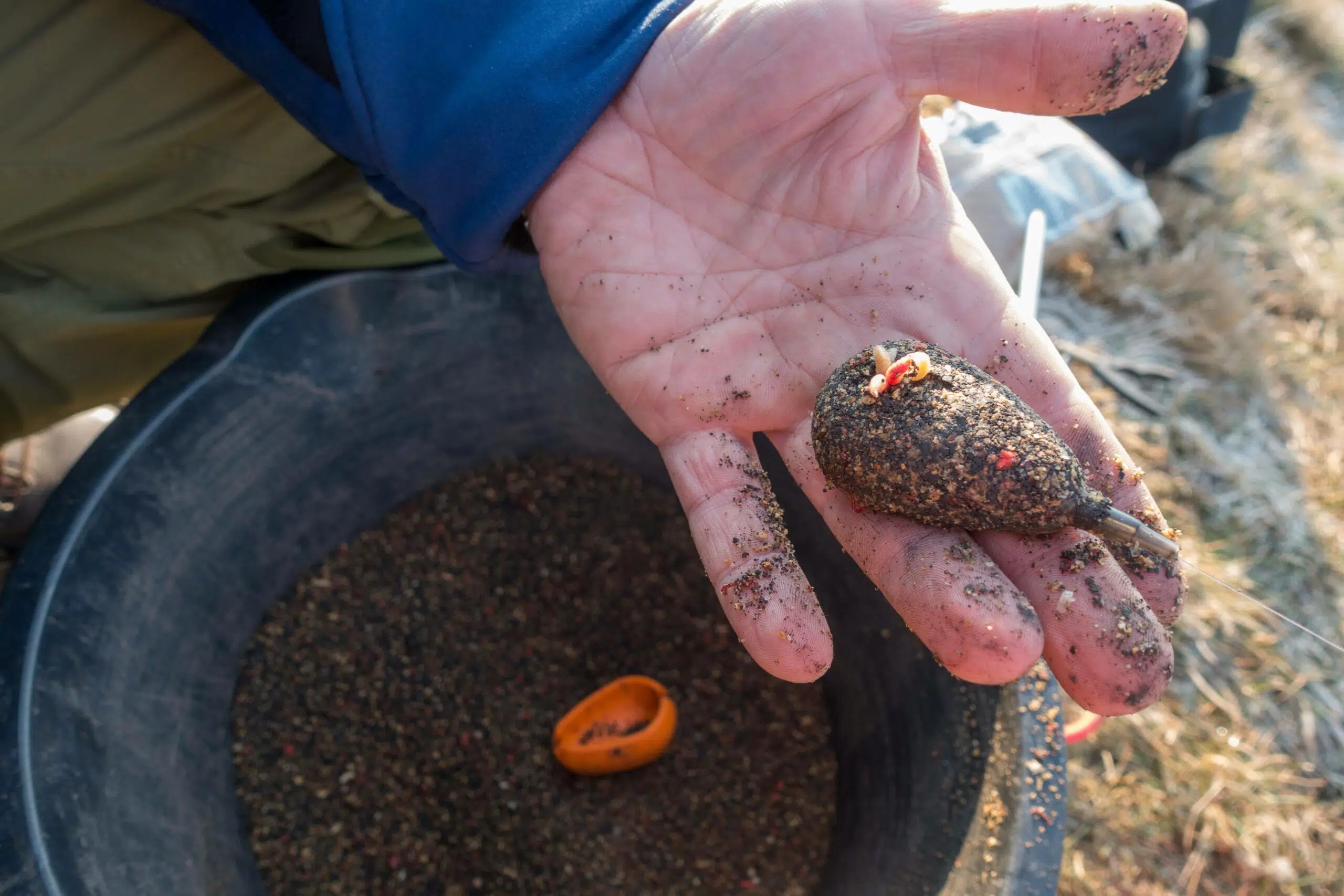How to fish a method feeder Man holding method feeder and moulded mix