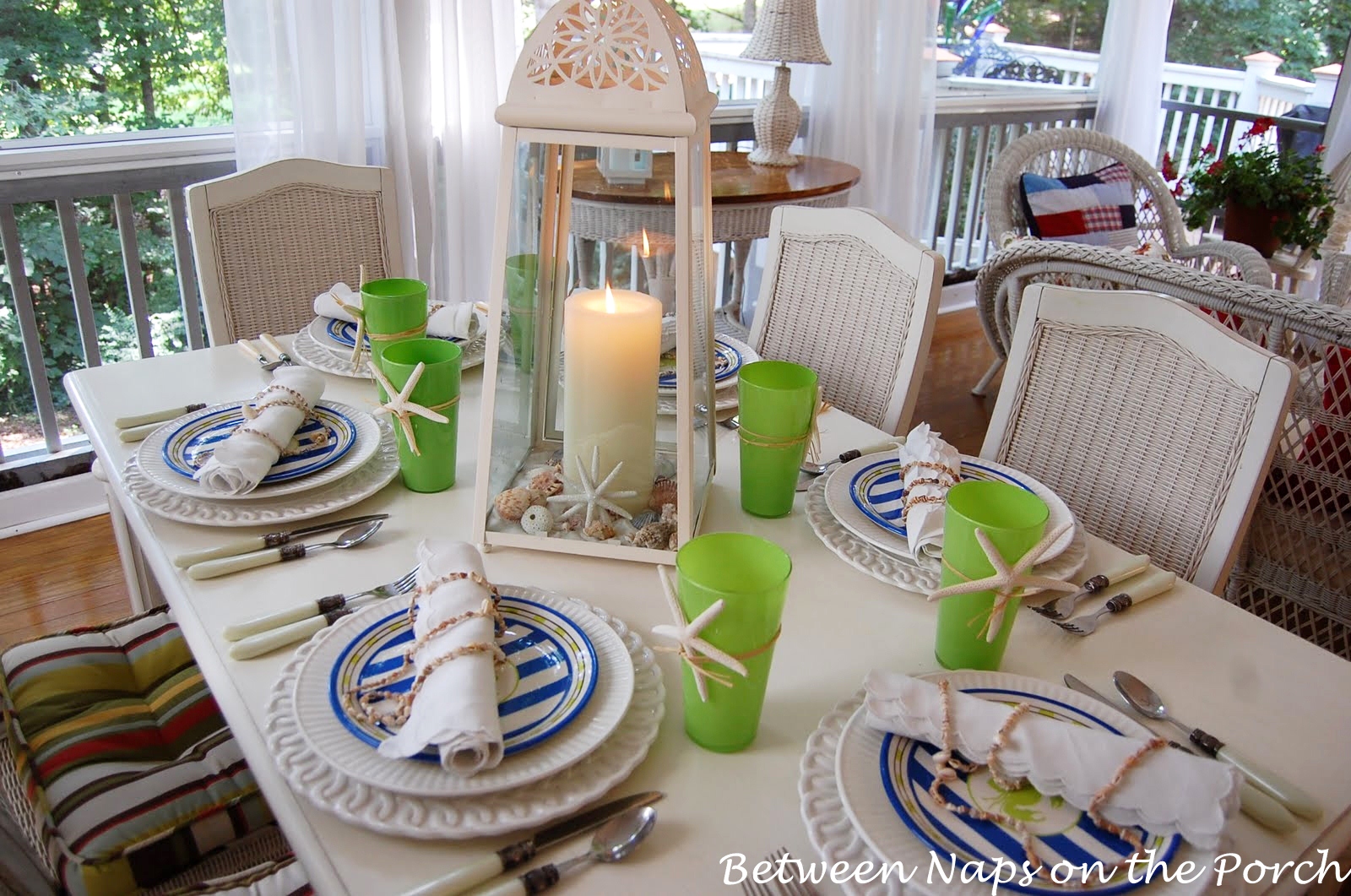 Beach Themed Tablescape Setting with a Lighthouse Style Lantern Centerpiece and Shell Napkin Holders