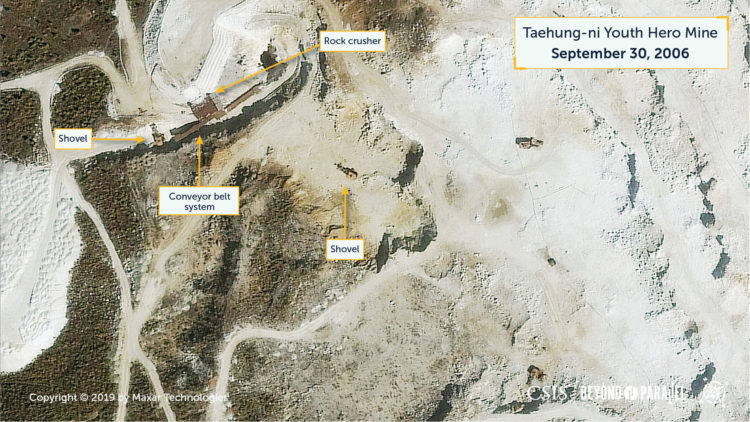 Close-up of the rock crusher and shovels, ore haul tucks, and drills at the Taehung Youth Hero Mine, September 30, 2006. (Copyright 2019 by Maxar Technologies)