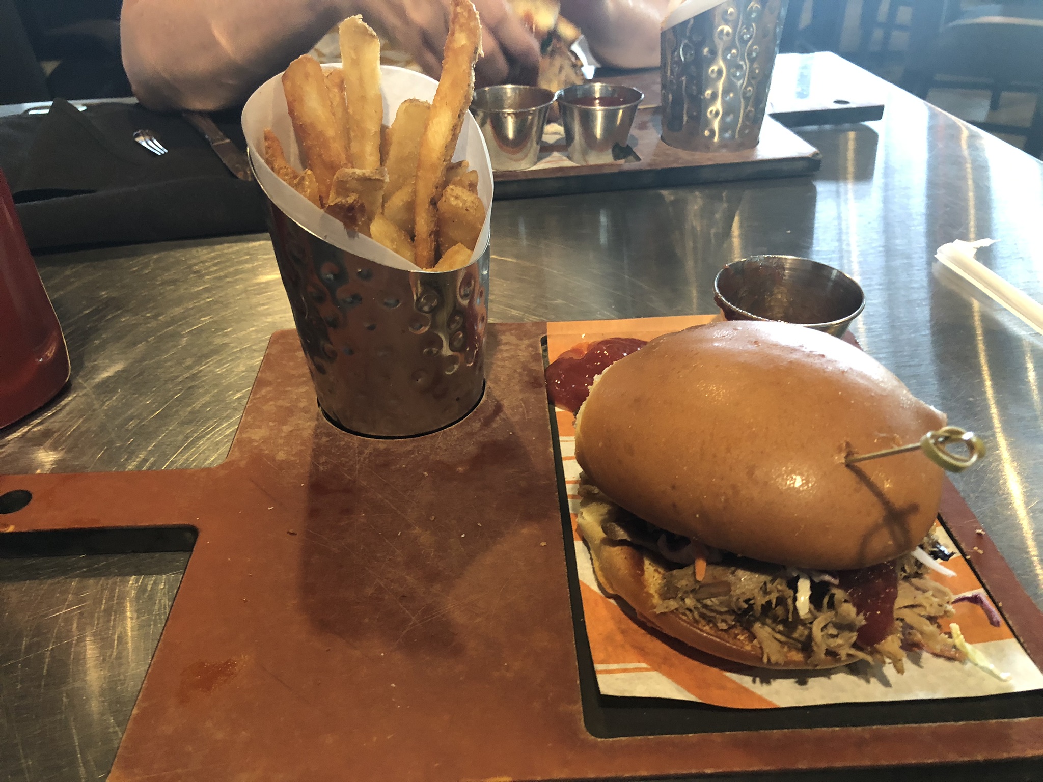 bbq pulled smoked pork sandwich on platter with fries