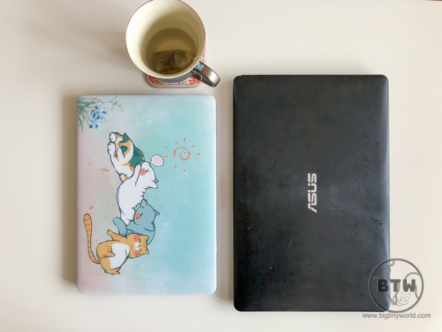 Two laptops with a spent cup of tea
