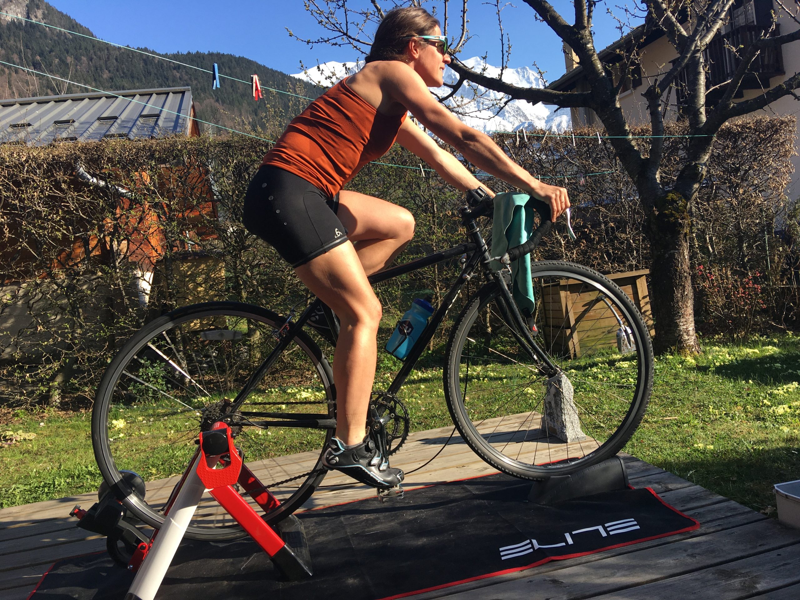 Mountain athlete Hillary Gerardi riding a stationary bike in her backyard in France.