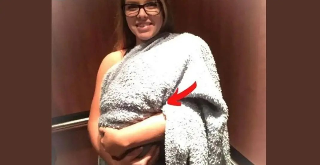 A woman enters the hospital with a blanketcovered bundle, assumed to