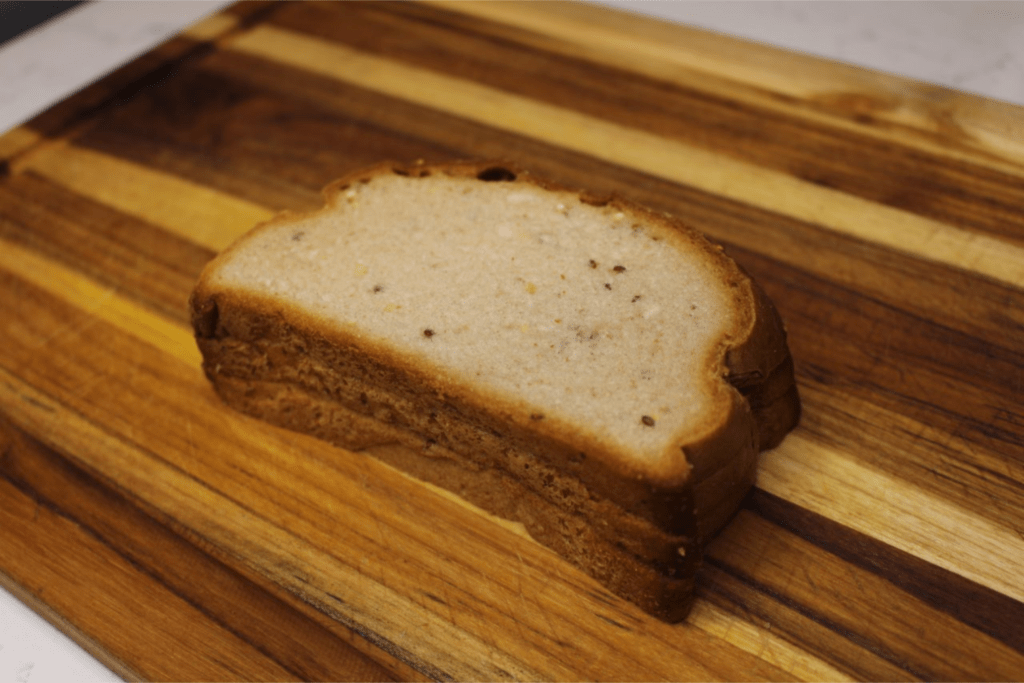 Three slices of bread stacked on top of each other on a cutting board