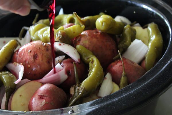 Red Wine Slow Cooker Roast with baby potatoes, onions and pickled peppers. This recipe has an Italian feel to it, and is still an All-American hearty meal.
