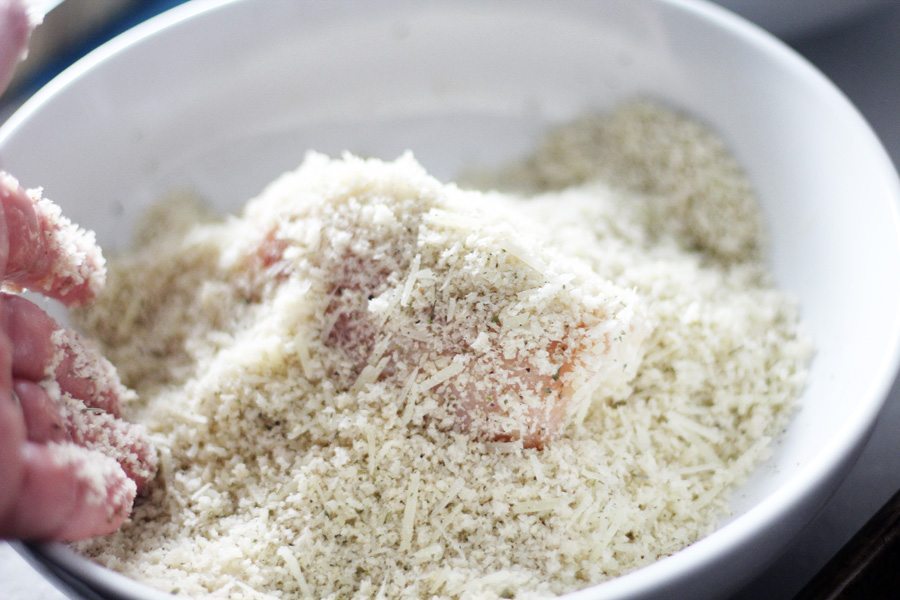 It is easiest to place the chicken parmesan rolls in the shallow dish of bread crumbs and coat with your hands. Chicken rolls being breaded in the panko bread crumb mixture by hand