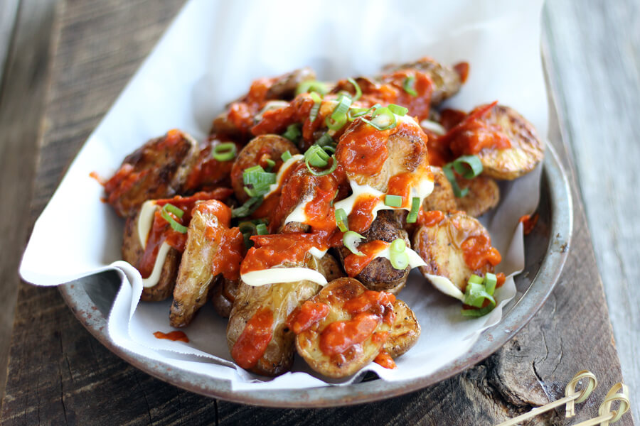 You'll want bite after bite of this Patatas Recipe. What is your favorite part? A completed recipe of Patatas Bravas on a plate on a wooden background