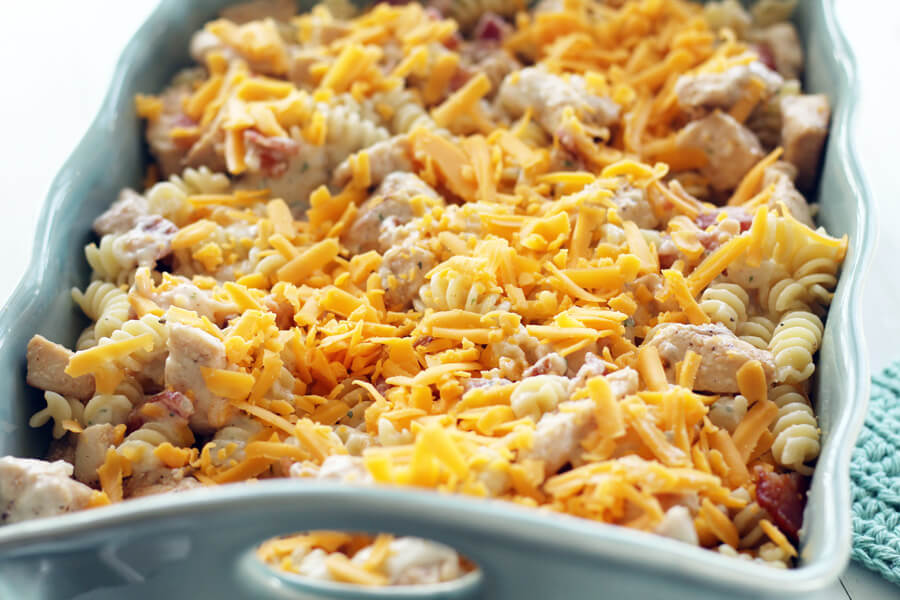 Layers of pasta, chicken, bacon and cheese in a casserole dish.