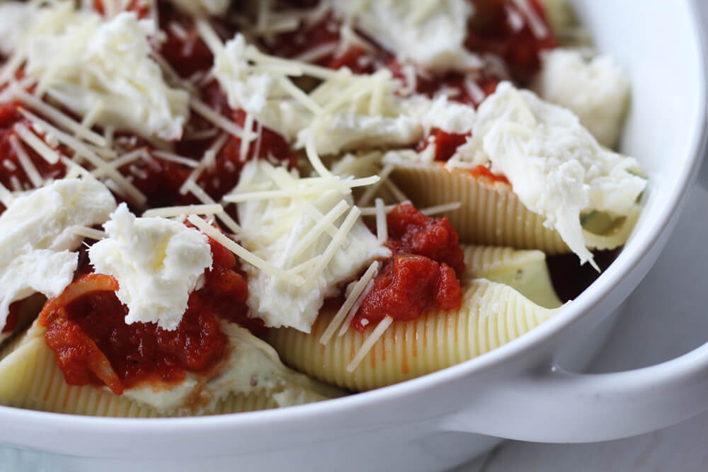 a close up picture of mozzarella cheese on top of sauce and pasta