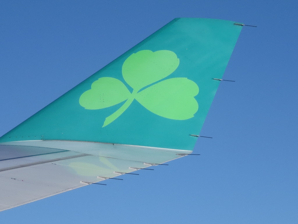 Aer Lingus green shamrock logo on airplane wing flying ove… Flickr