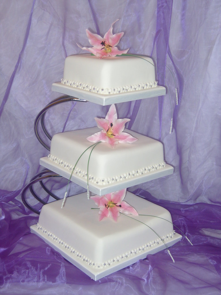 3 tier square wedding cake with lillies on stand Cakes
