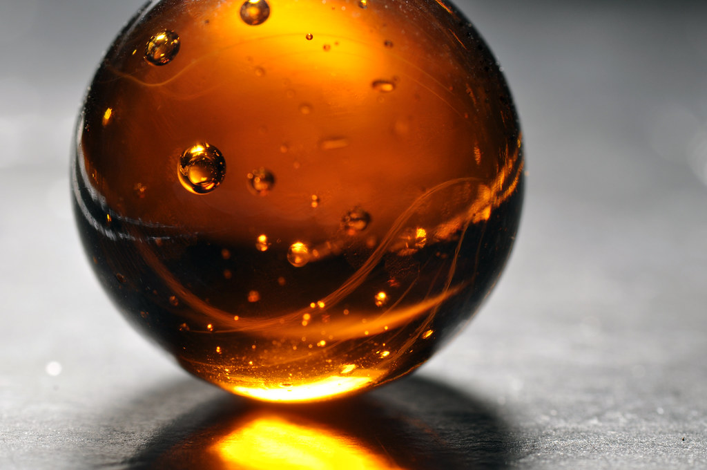 Glowing glass amber orb A macro image of a glass marble. n… Flickr