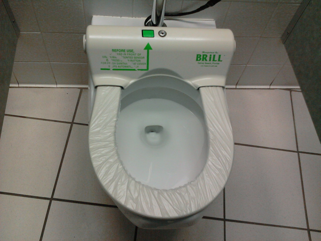 Toilet seat cover on a conveyor belt. Push button to advan… Flickr