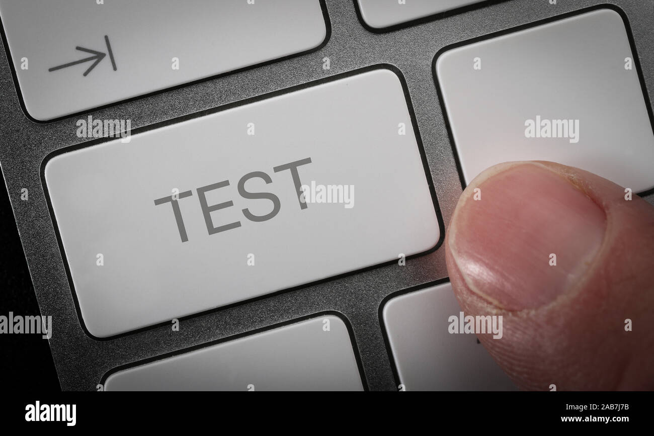 A man pressing a key on a computer keyboard with the word test. Online