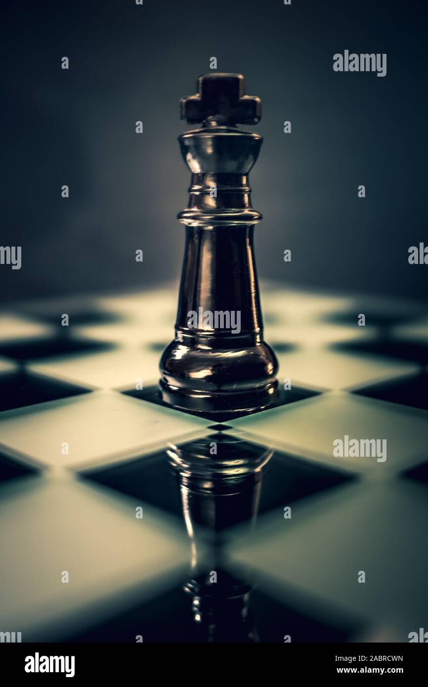 Black glass King chess piece on dramatic background Stock Photo Alamy
