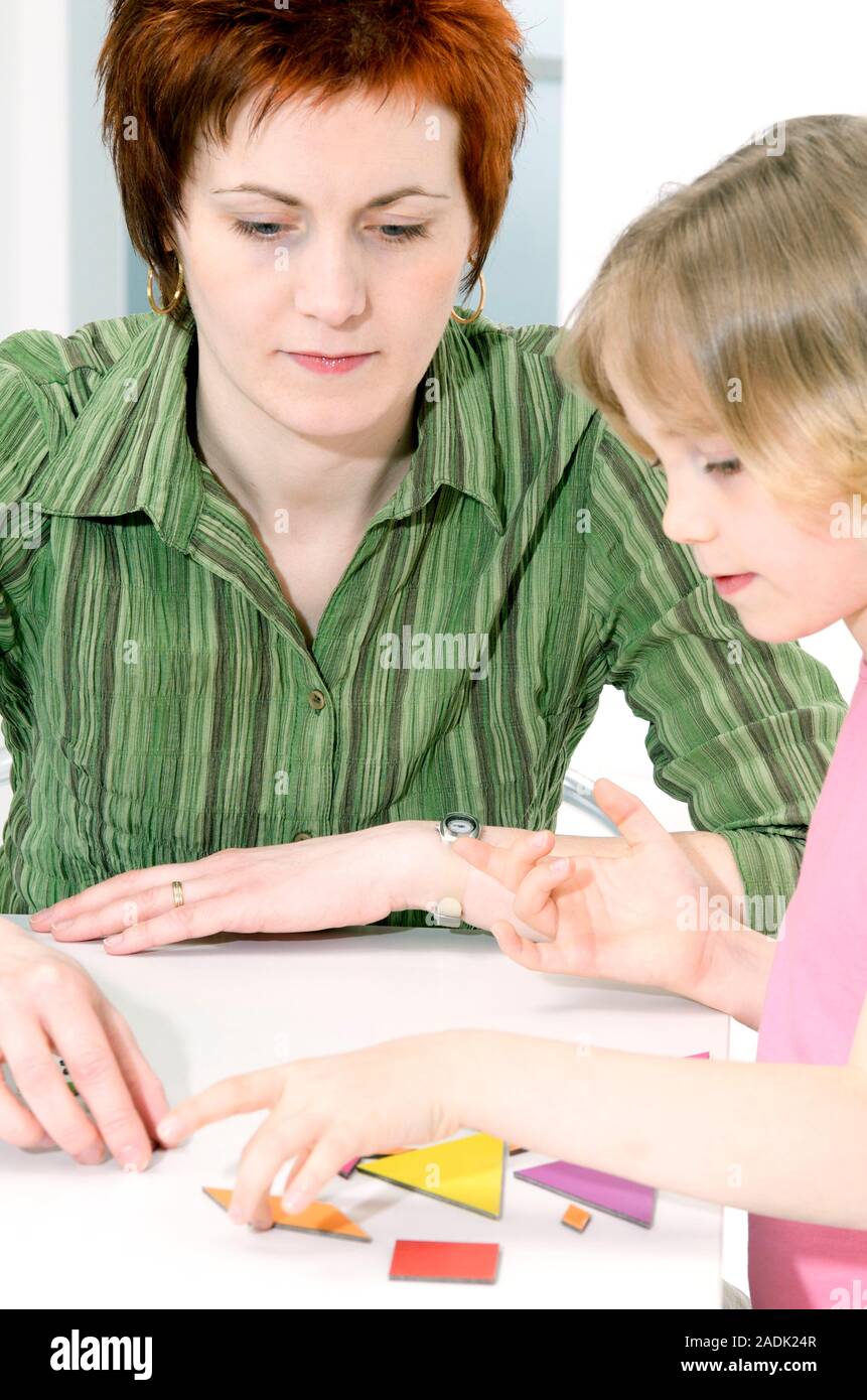 Logic game. Child psychologist with a girl who is playing a logic game