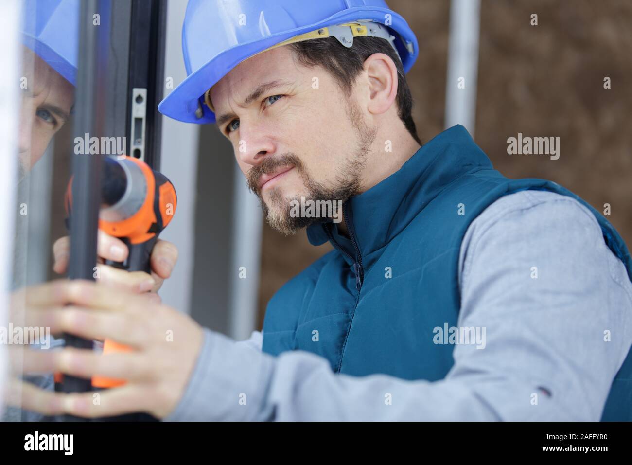 construction worker using drill to install window Stock Photo Alamy
