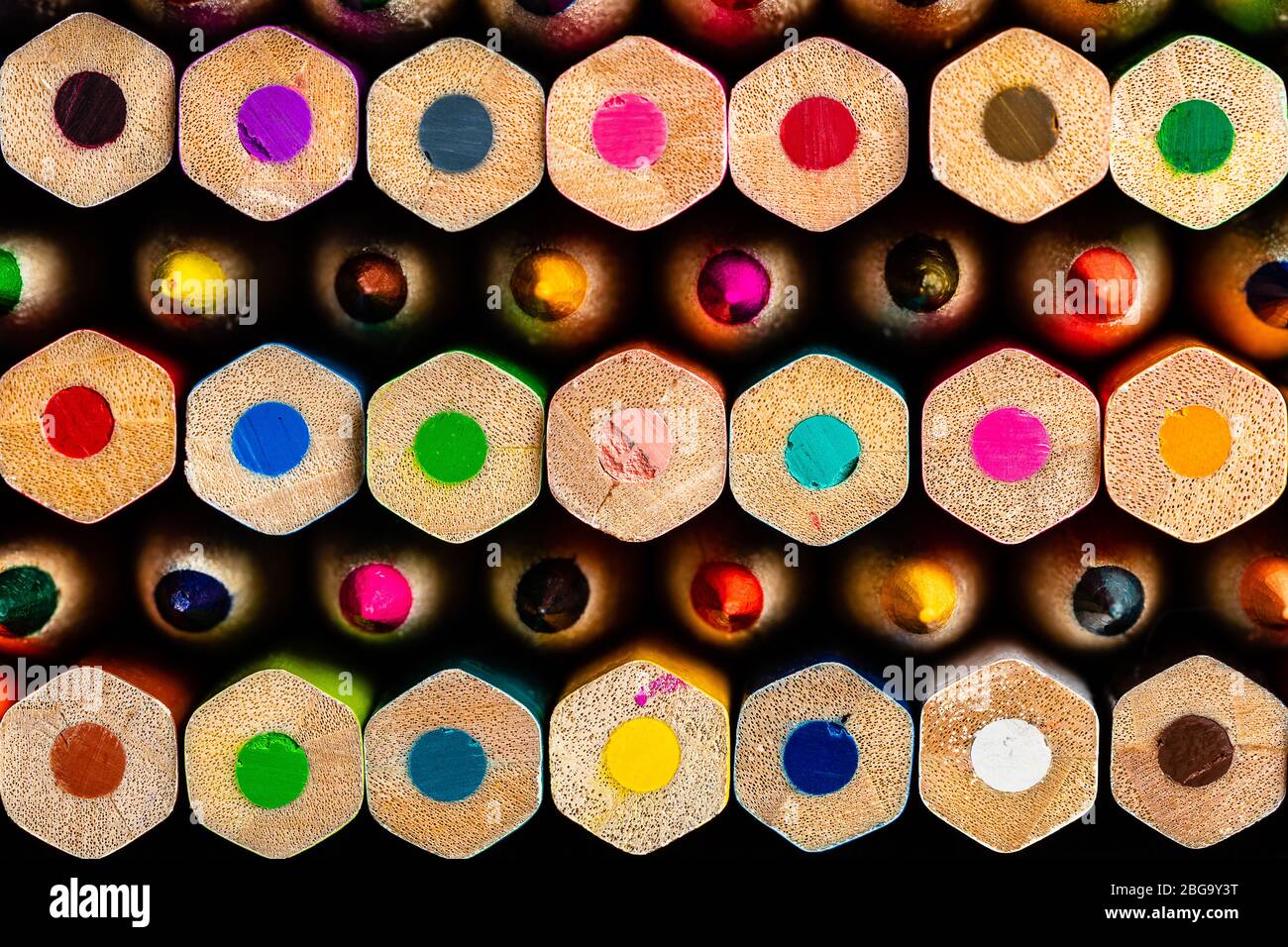 A macro frame of a stack of colored pencils with rows alternating