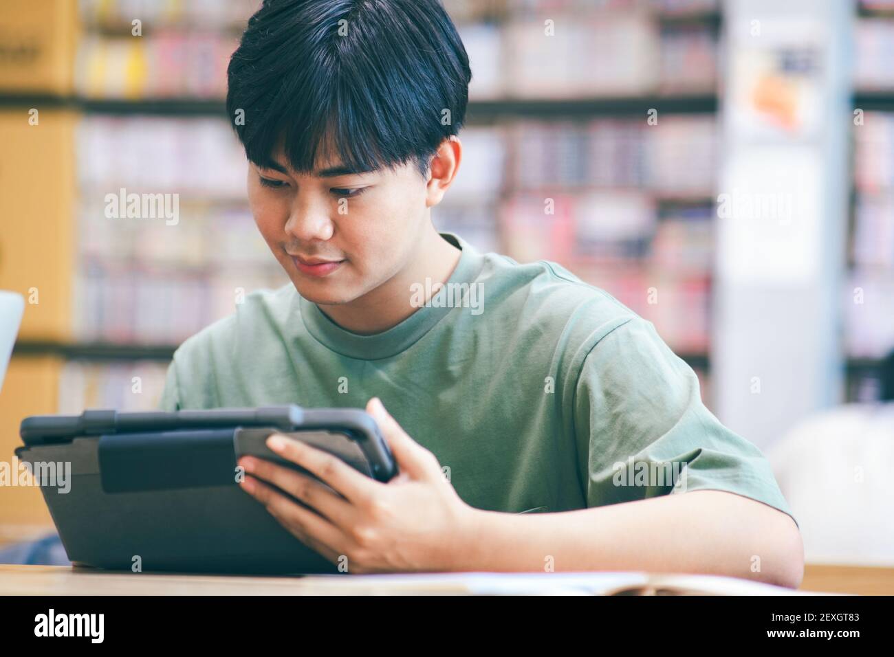 Young collage student using computer and mobile device studying Stock