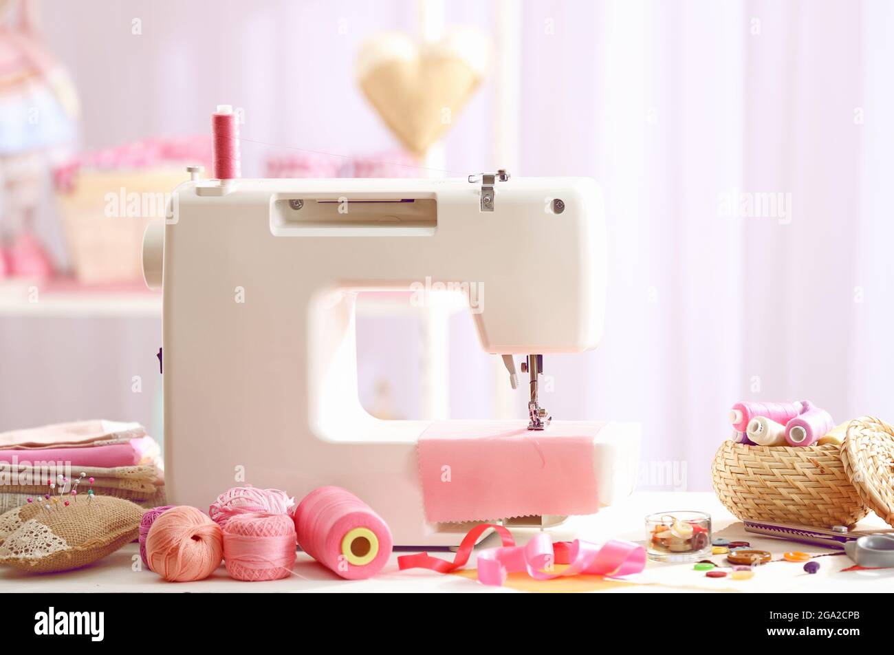 Sewing machine on table in Stock Photo Alamy