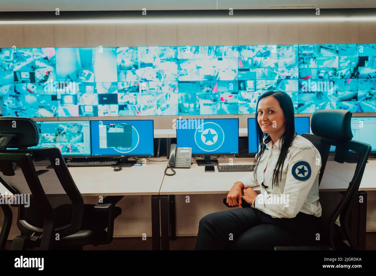 Female security operator working in a data system control room offices