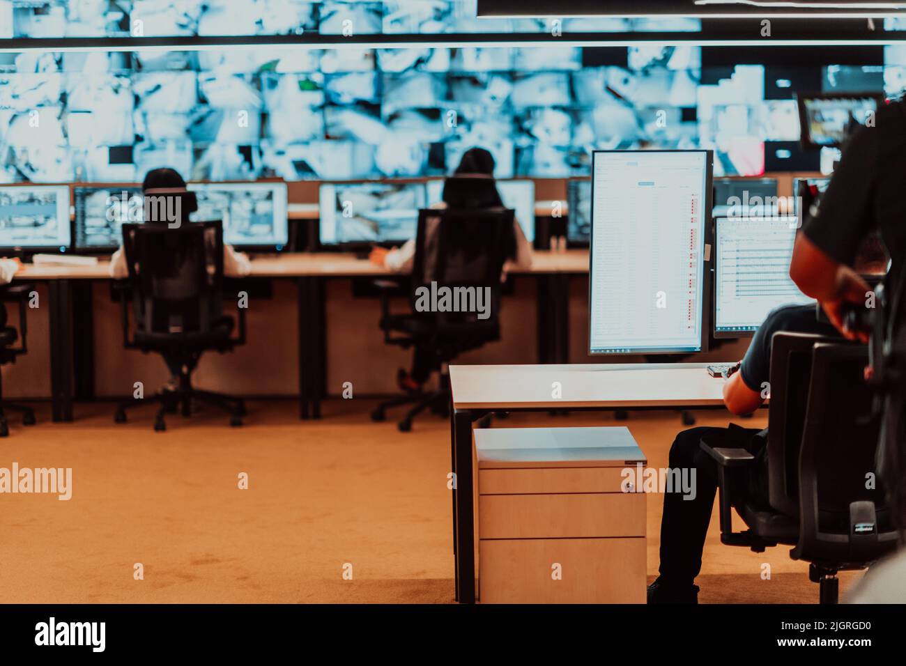 Male security operator working in a data system control room offices