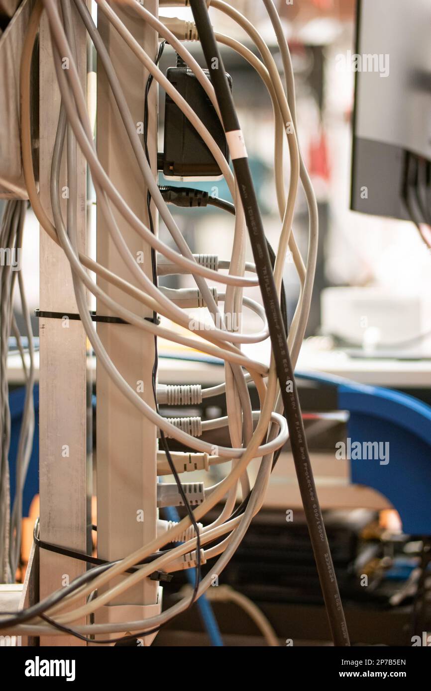Power extension cord with multiple sockets, multiple power cords plugged in, inside a lab. Close