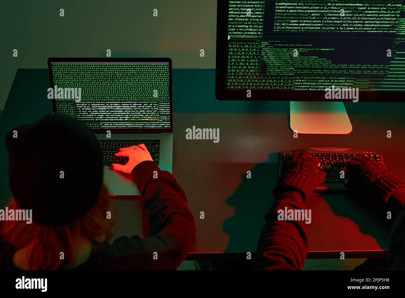 Anonymous people using computer and programming to break code. Cyber