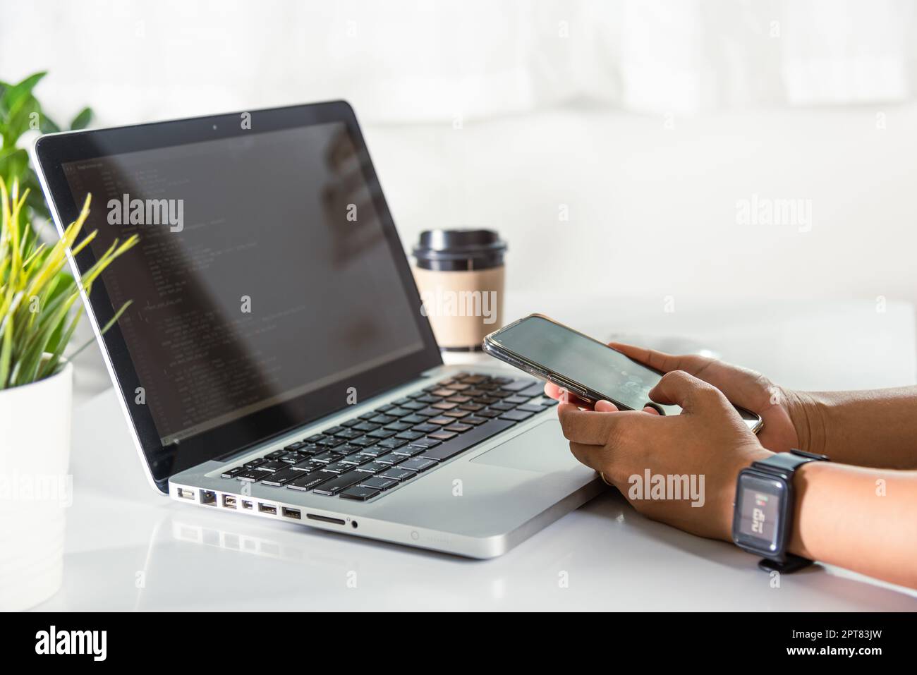 Programmer woman looking mobile phone program code at workplace