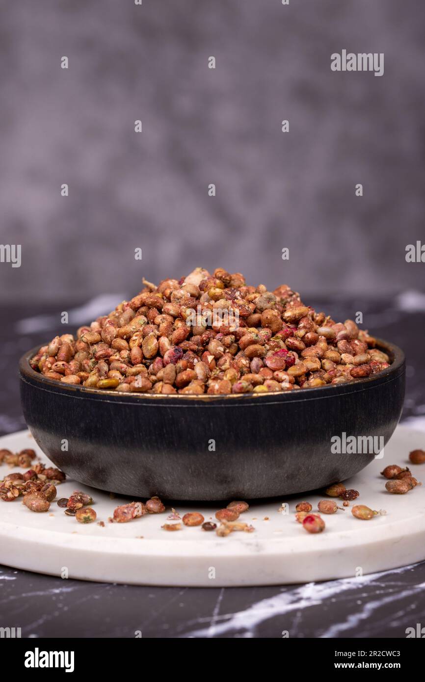 Sumac seeds. Dried sumac berries on dark background. Spice concept