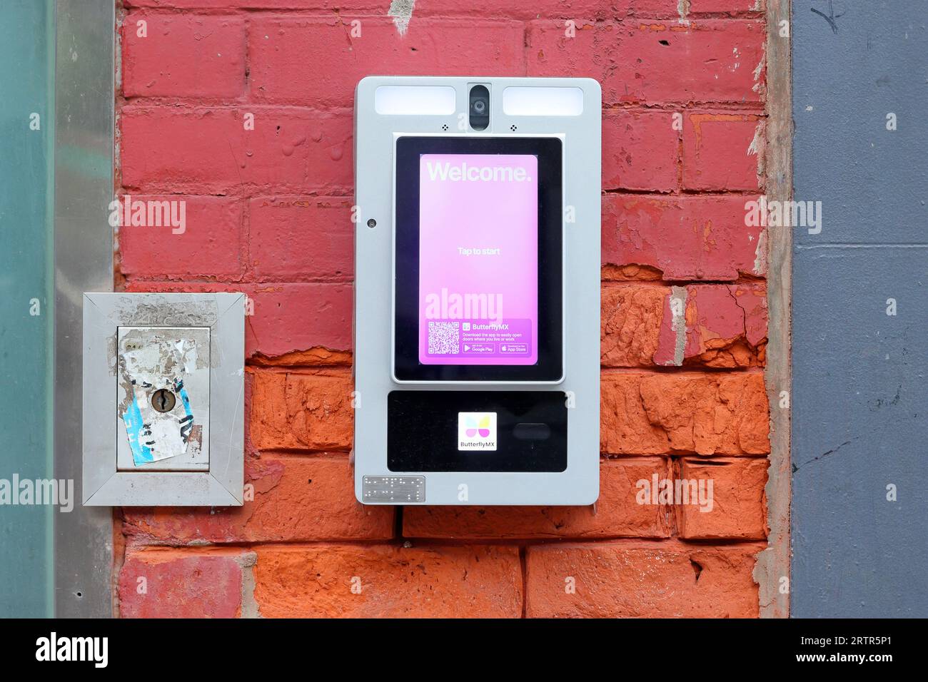 A USPS key keeper box next to a ButterflyMX smart system for