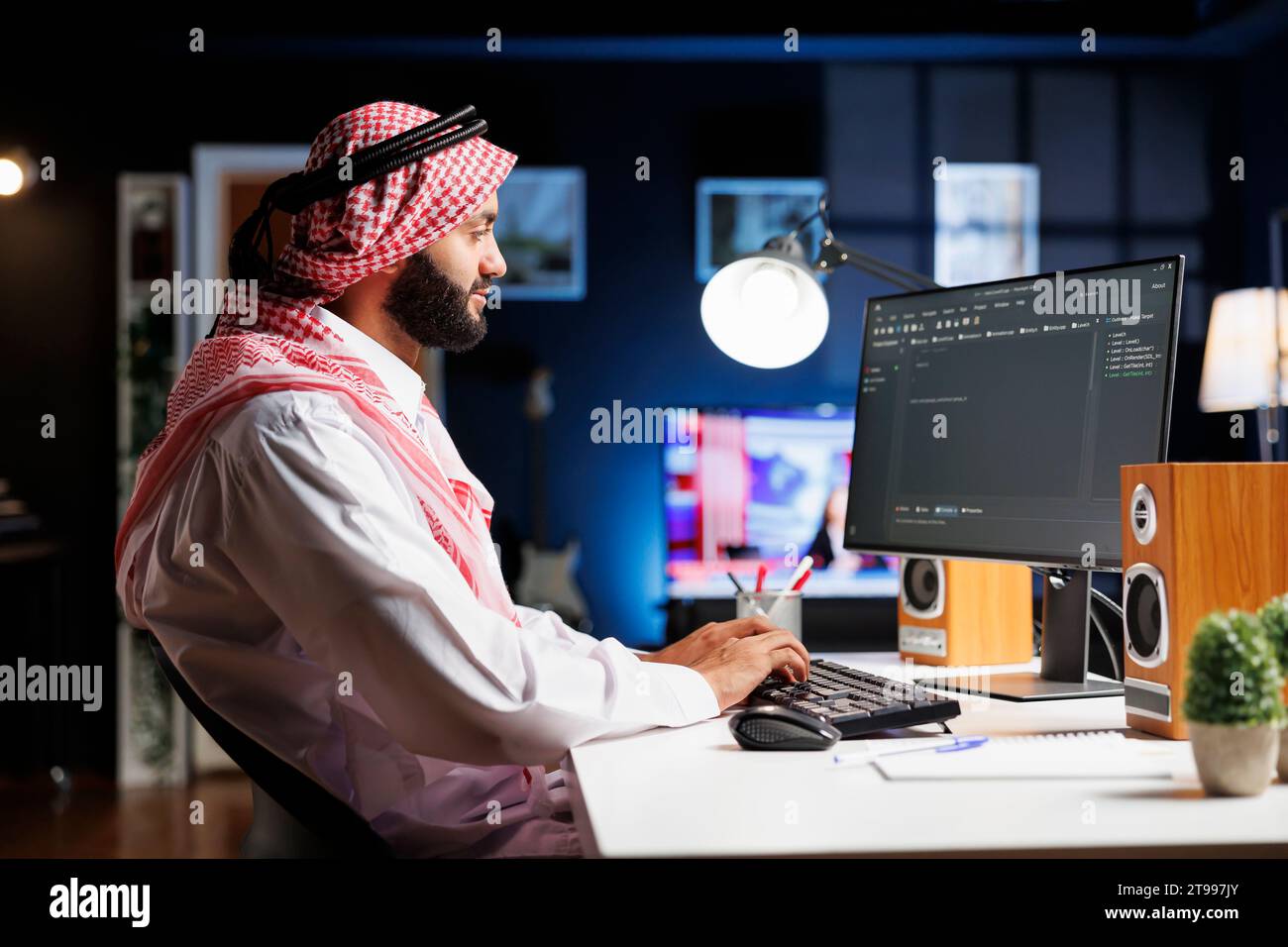 Image shows an Arab software developer working at the pc monitor
