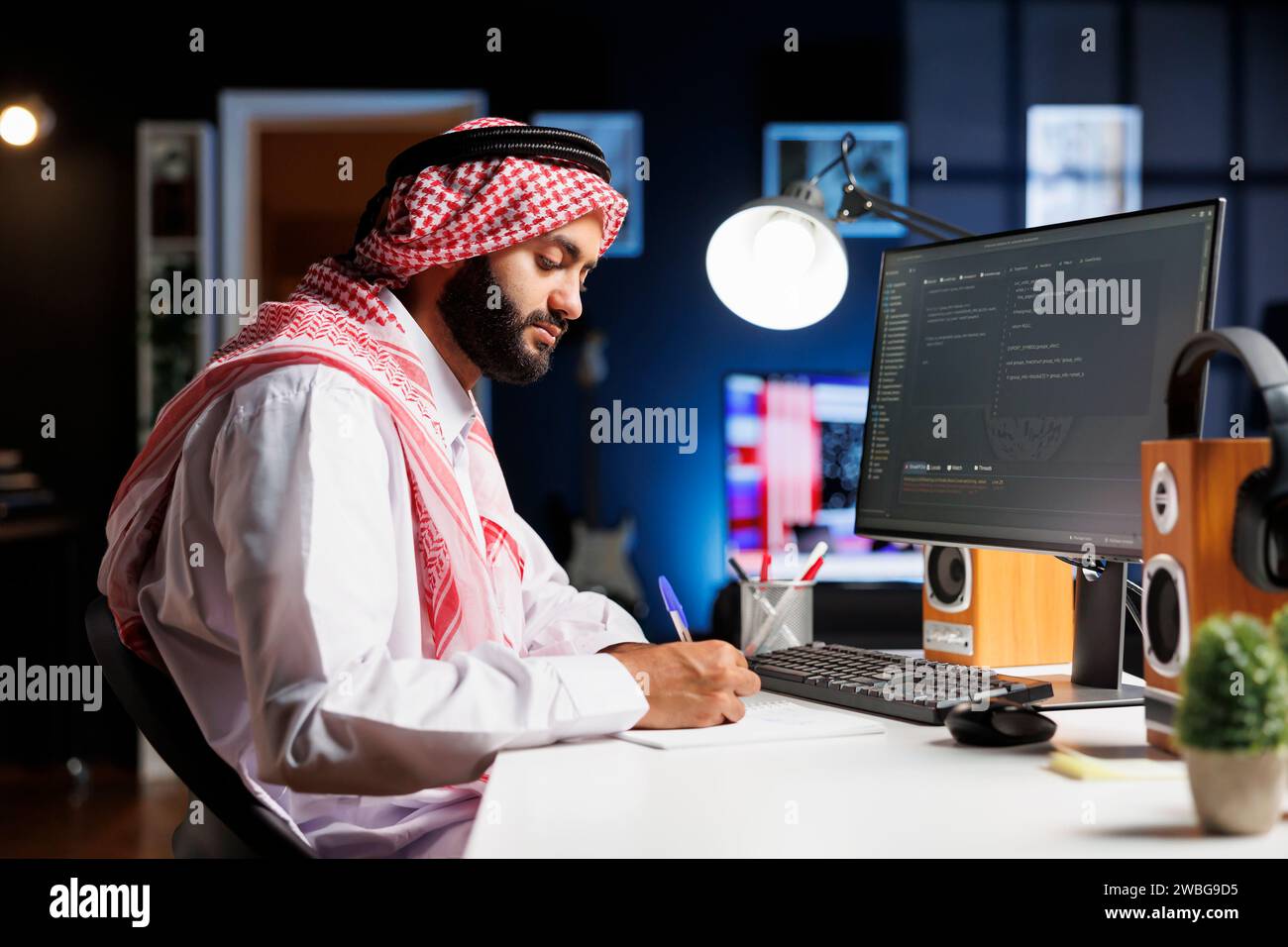 Muslim man sits at a computer and programs, exhibiting the app