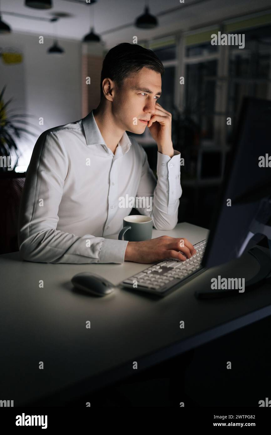 Vertical portrait of IT programmer checking computer code using desktop