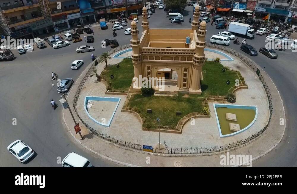 Long shot of Char Minar Chowrangi with traffic passing by in