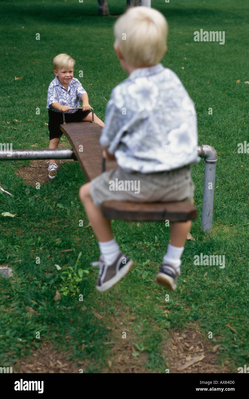 Caucasian boys playing teeter totter hires stock photography and