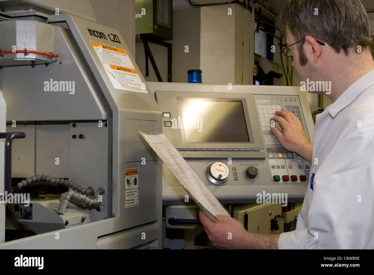 CNC lathe operator programming in data & setting up a task Stock Photo Alamy