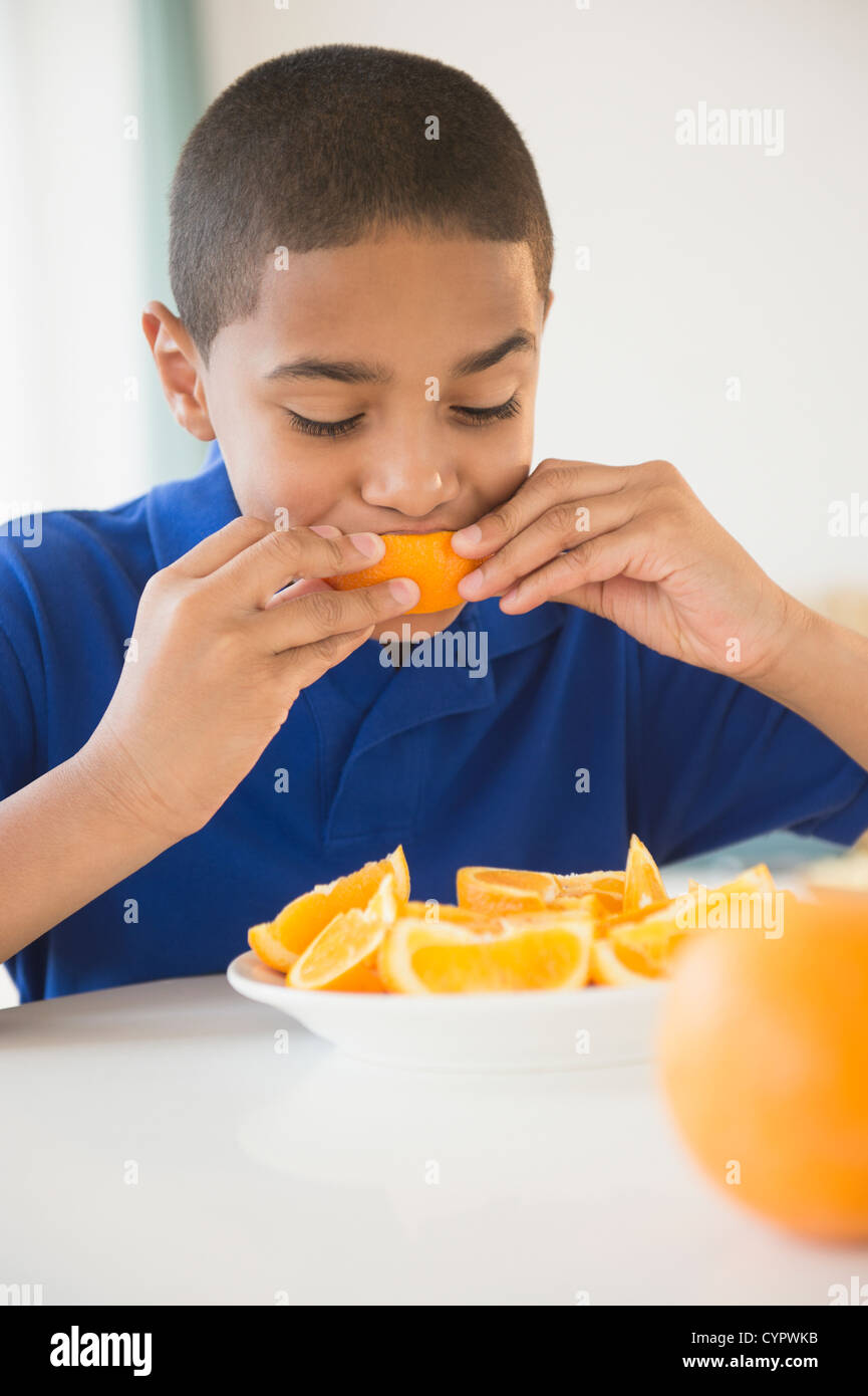 Hispanic boy eating orange sections Stock Photo Alamy