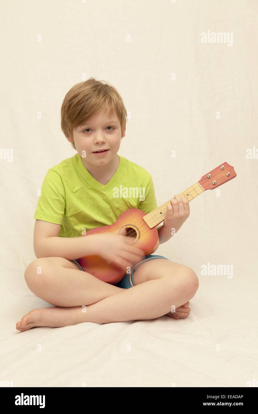 young boy playing ukulele Stock Photo Alamy