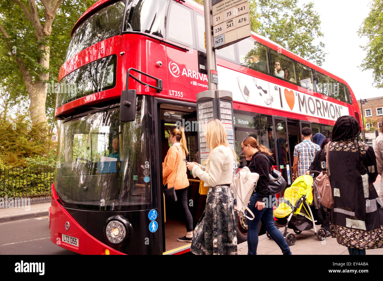 People in a queue to get on a london bus, passengers boarding bus