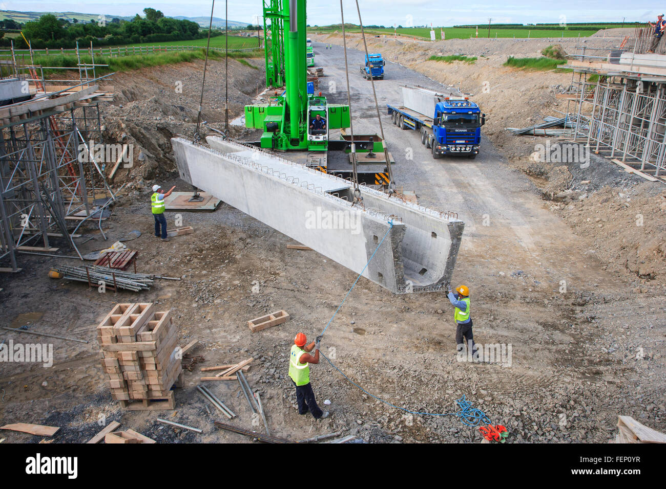 construction workers on road infrastructure construction using crane to