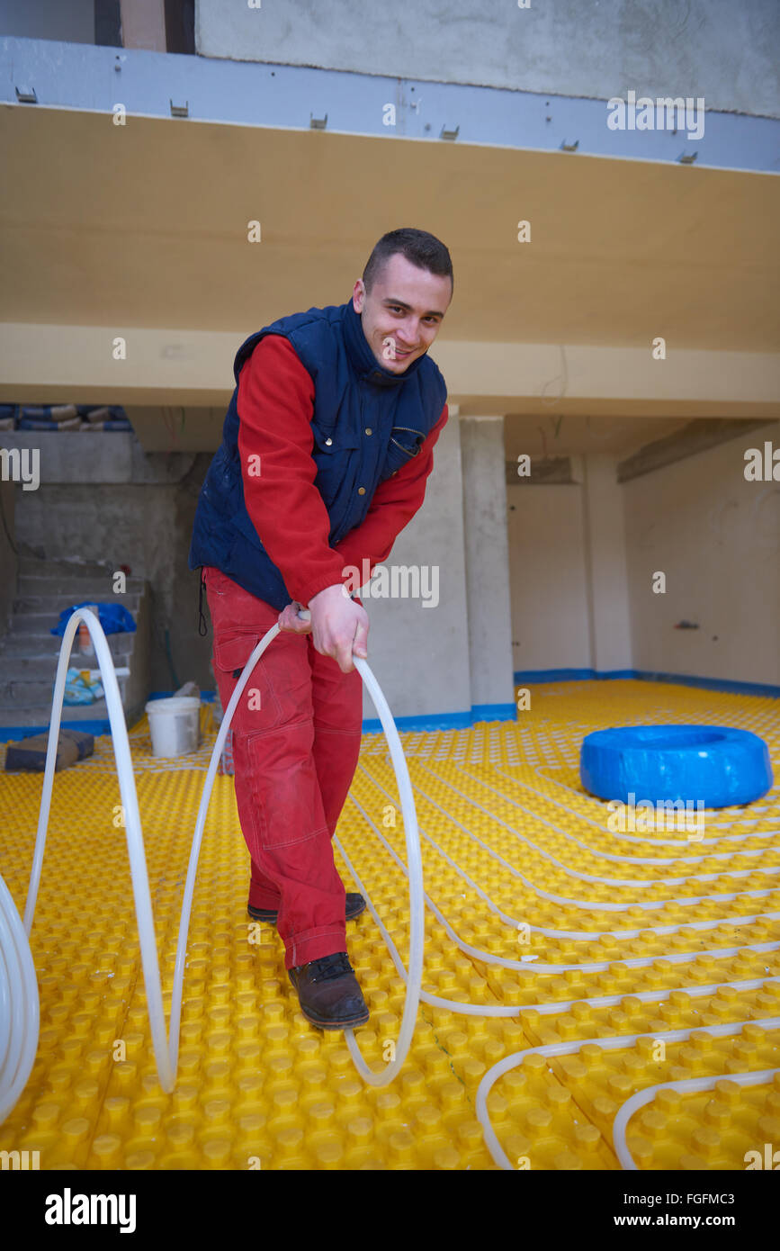 workers installing underfloor heating system Stock Photo Alamy