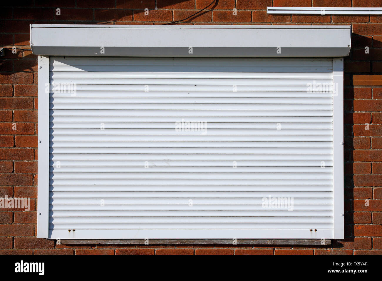Closed serving hatch security shutters with brick background Stock
