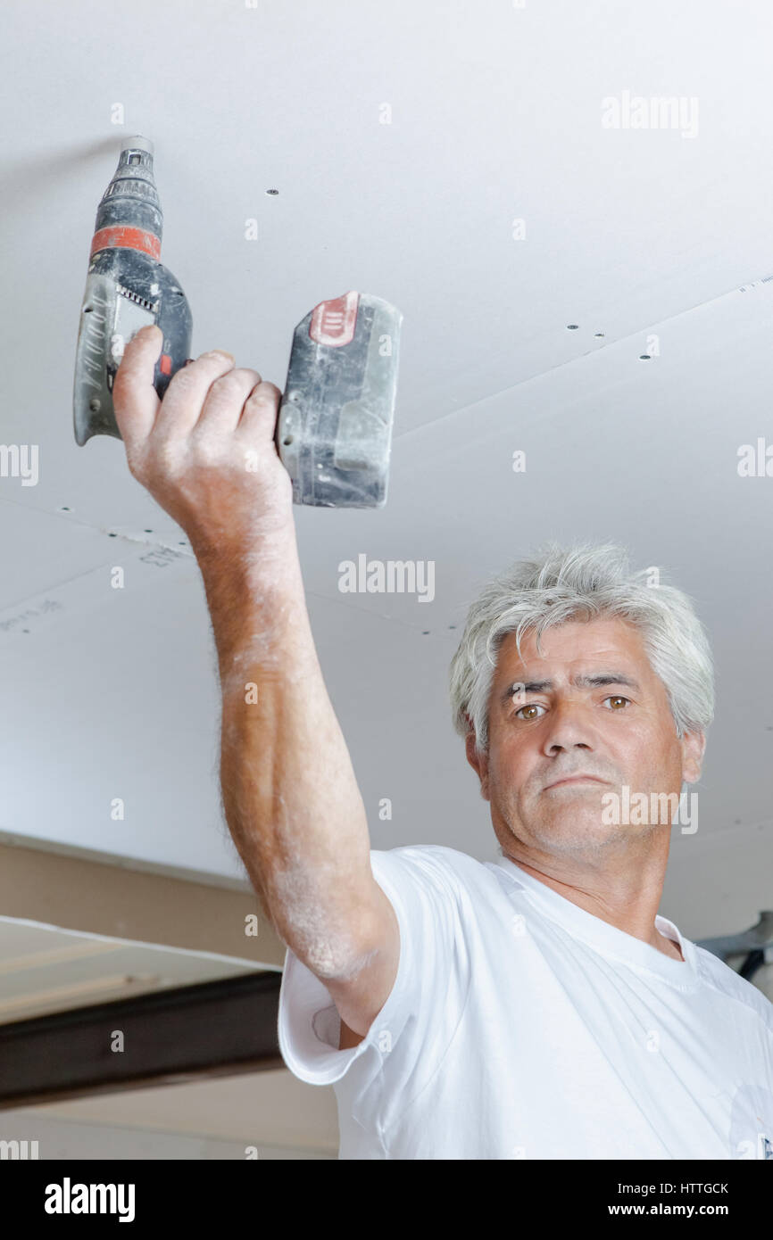 Mason drilling into the ceiling Stock Photo Alamy