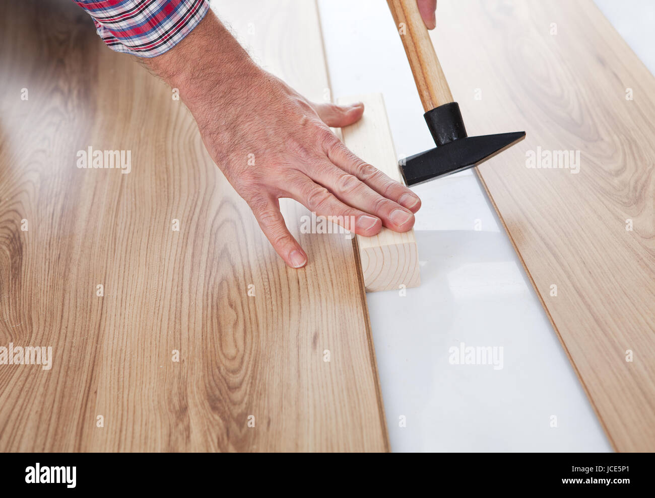 Worker assembling laminate floor using a hammer Stock Photo Alamy