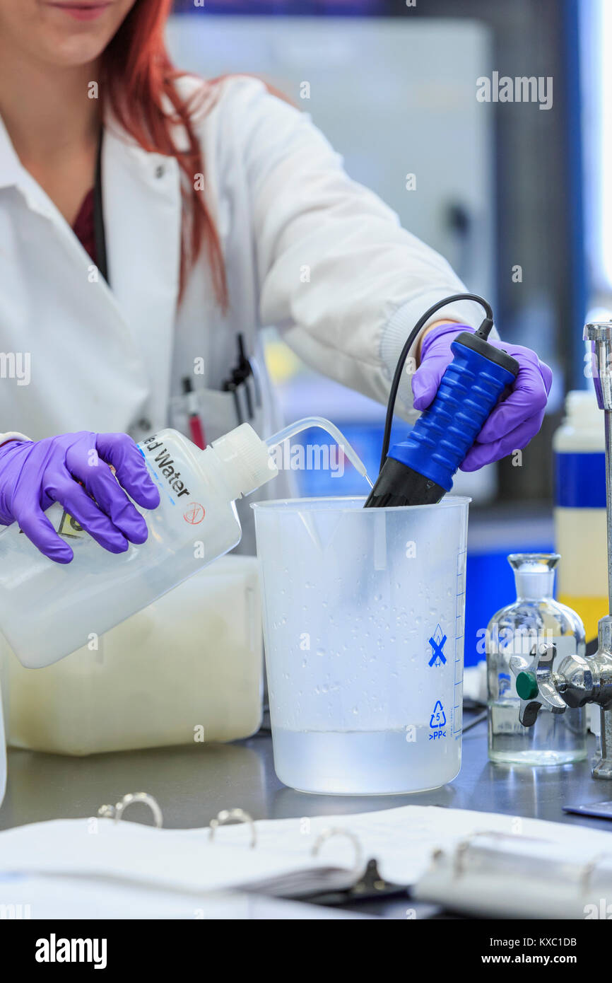 Lab chemist adding distilled water while measuring pH Stock Photo Alamy