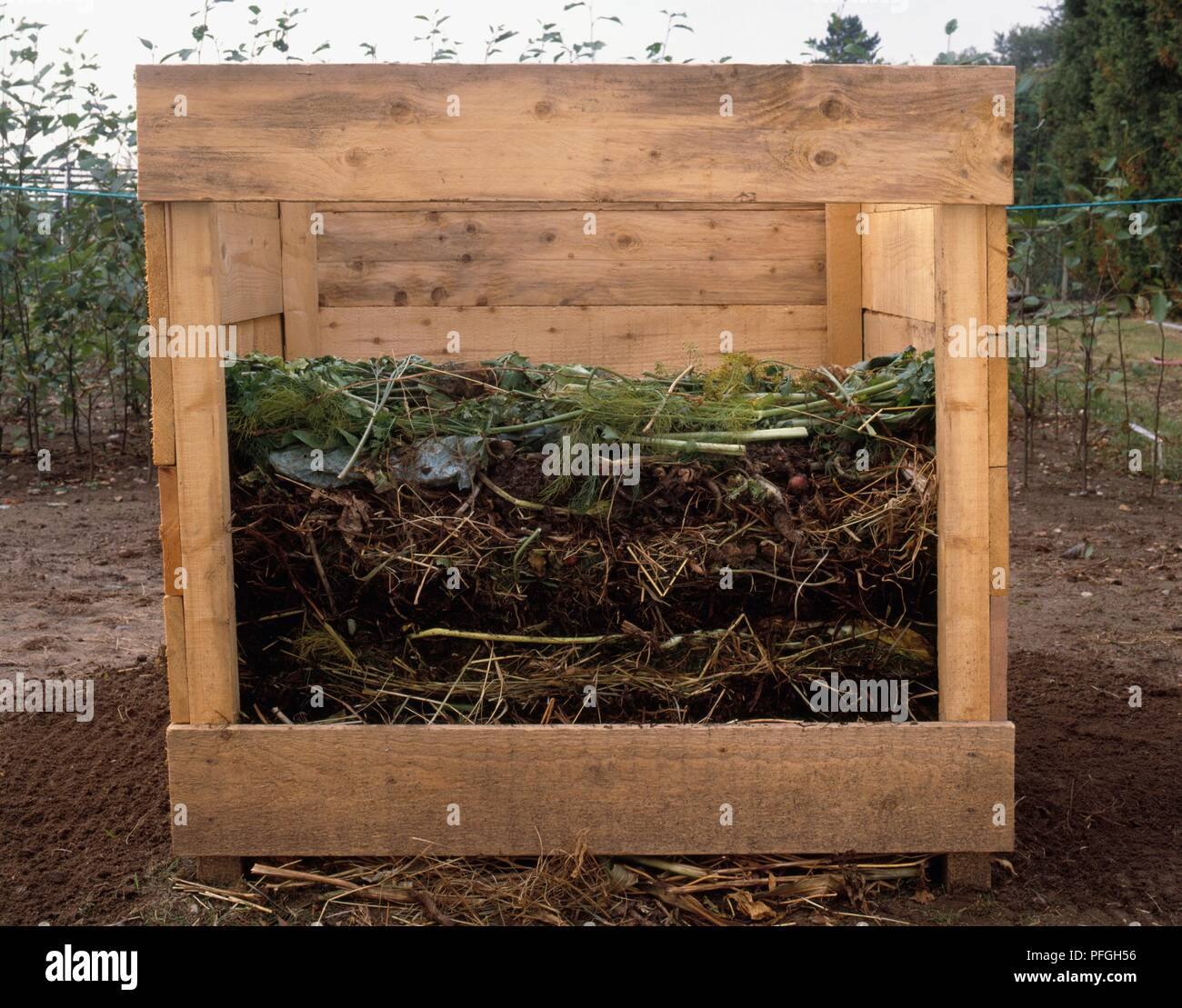 Crosssection of compost bin showing thick layer of twiggy material at base and subsequent