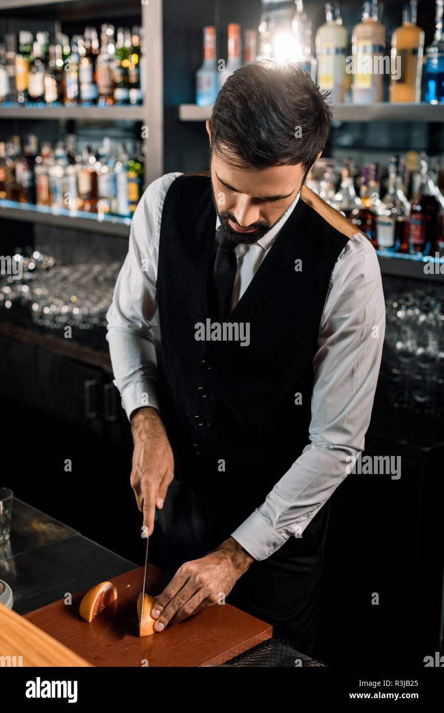 Bartender standing in bar and cutting fruit Stock Photo Alamy